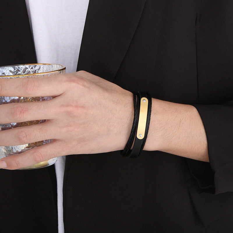Bracelet homme en simili cuir noir tressé double tour avec plaque acier dorée gravée.
