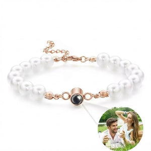 Bracelet perlé blanc avec chaîne ajustable en acier doré et projection photo intégrée au centre noir.