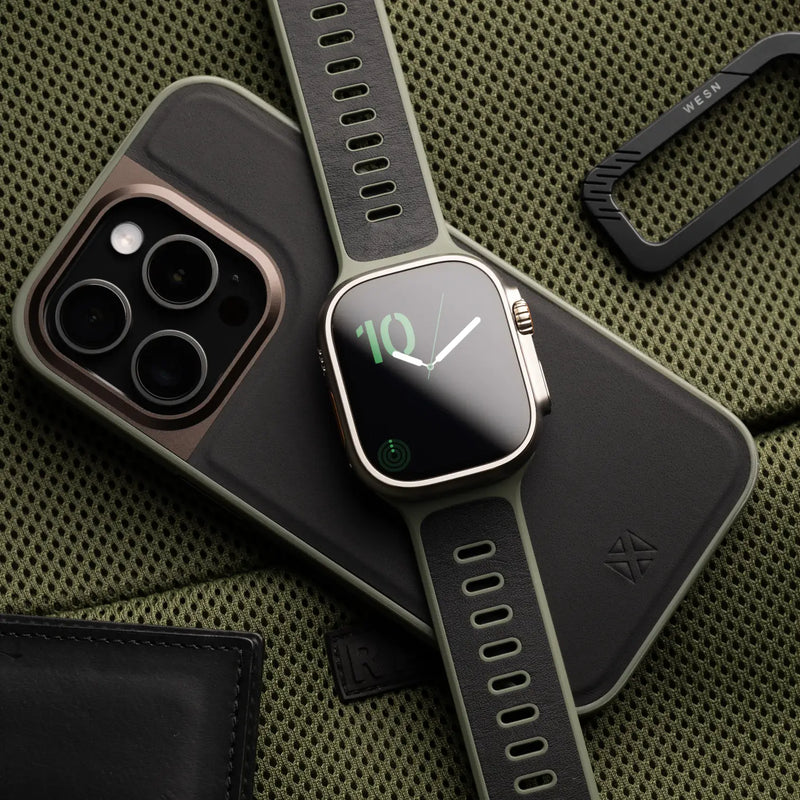 Bracelet Apple Watch hybride en cuir noir et fluoroélastomère gris foncé avec boucle ajustable en métal argenté.