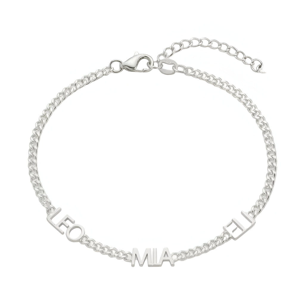 Bracelet en acier inoxydable argenté avec maille cubaine fine et trois prénoms découpés, fermoir cœur ajustable.