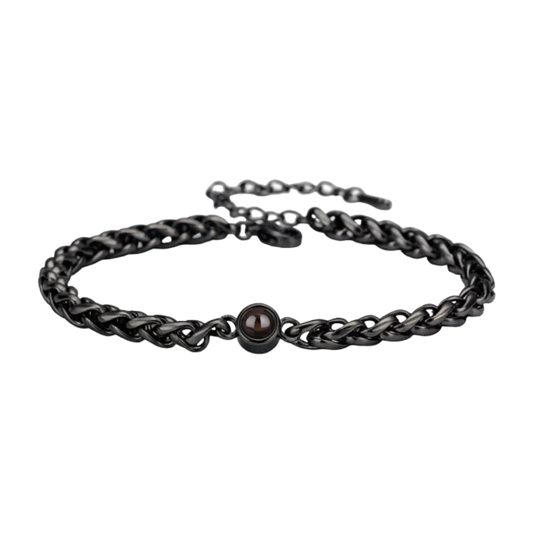 Bracelet maille tressée en acier inoxydable noir avec perle centrale brillante et fermoir réglable.