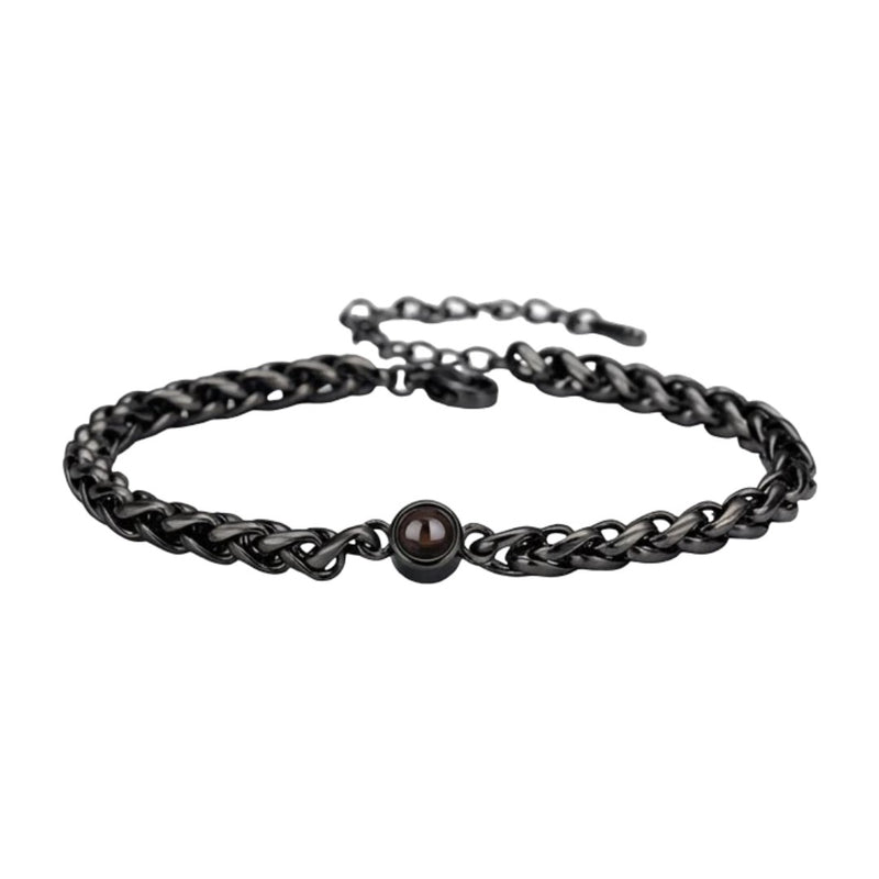Bracelet maille tressée en acier inoxydable noir avec perle centrale brillante et fermoir réglable.