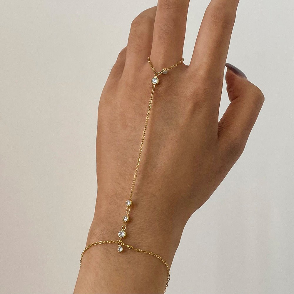 Bracelet chaîne de doigt doré en acier inoxydable avec petits zircons blancs, style délicat et sophistiqué.