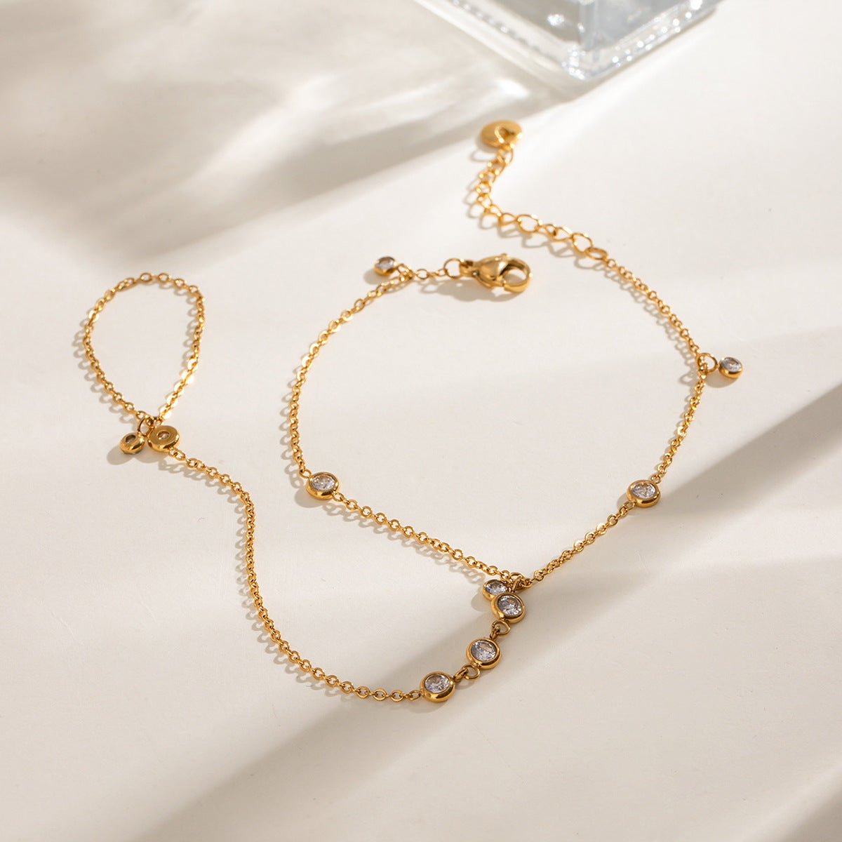 Bijou de main doré en acier inoxydable avec petites chaînes délicates et zircon blanc brillant, design élégant et fin.