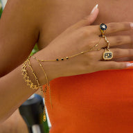 Bijou de main doré en acier inoxydable avec zircon noir, chaîne fine, style bohème, porté au doigt et poignet.