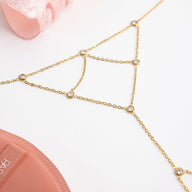 Bijou de main doré en acier inoxydable avec chaînes fines et pierres scintillantes rondes, design élégant et délicat.