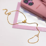 Bijou de main doré en acier inoxydable, chaînette fine maille cubaine avec papillon central et perles blanches.