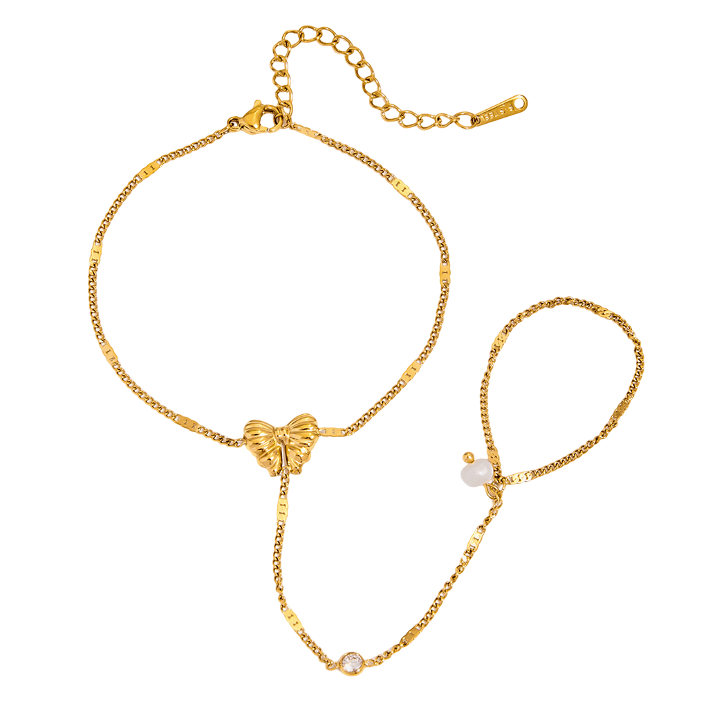 Bijou de main papillon en acier doré, chaîne cubaine fine, perles blanches et zircons transparents.