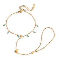 Bijou de main doré en acier inoxydable avec chaînette fine, perles turquoise et petits cœurs suspendus.