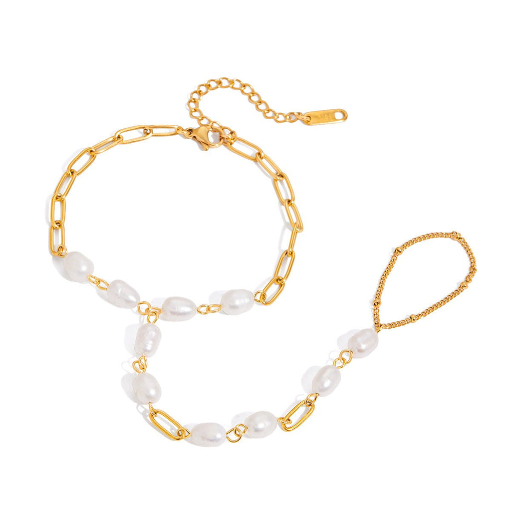 Bracelet de main doré en acier inoxydable avec chaîne fine et perles blanches ovales, modèle Urima.