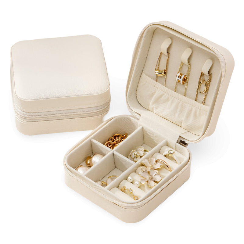 Boîte à bijoux nomade Oria beige avec compartiments et porte-bagues intégré.