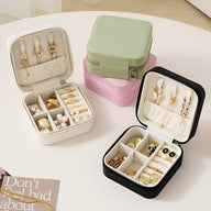 Lot de boîtes à bijoux nomades Oria en cuir blanc, noir, vert et rose avec compartiments et rangement pour boucles.