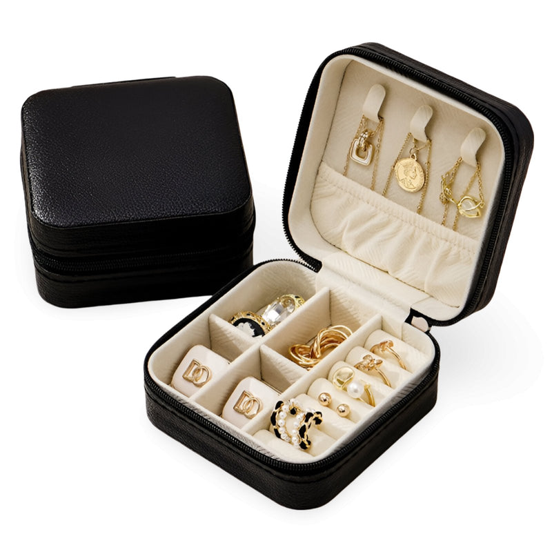 Boîte à bijoux nomade Oria noire en simili cuir avec intérieur beige et compartiments pour bagues, boucles et montre.