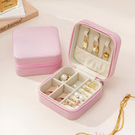 Boîte à bijoux nomade Oria rose ouverte avec compartiments et rangements pour bagues et boucles d’oreilles, ambiance élégante.