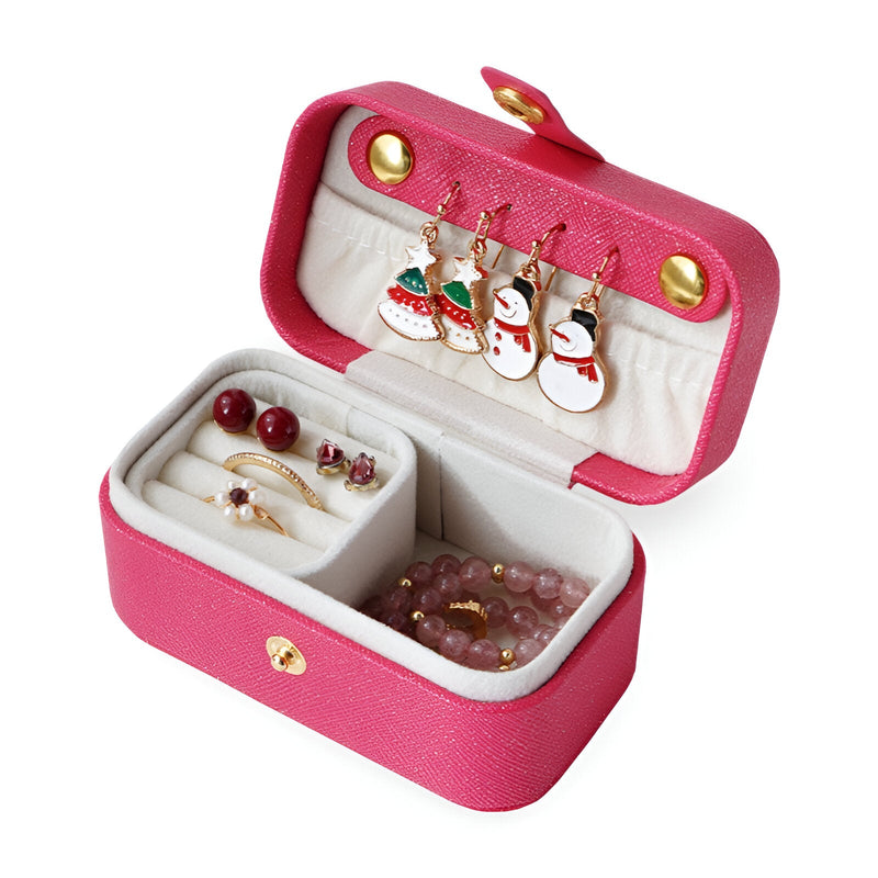 Boîte à bijoux rose fuchsia en simili cuir avec intérieur beige et compartiments pour bijoux.