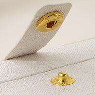 Fermoir bouton-pression doré sur boîte à bijoux nomade blanche texturée modèle Céleste.