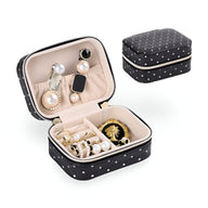 Boîte à bijoux noire à pois blancs, intérieur beige avec compartiments et boucle d'oreille en perles, strass sur couvercle.