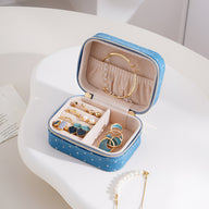Boîte à bijoux nomade bleue à strass avec compartiments et rangement pour bagues et boucles d’oreilles.