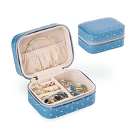 Boîte à bijoux nomade bleue avec strass et intérieur beige compartimenté pour bagues et boucles d'oreilles.