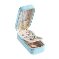 Boîte à bijoux nomade allongée bleue avec compartiments et doublure crème, rangement boucles d’oreilles et bracelets.
