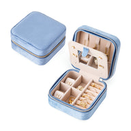 Boîte à bijoux nomade Monica en velours bleu clair avec compartiments et porte-bagues intérieur beige.