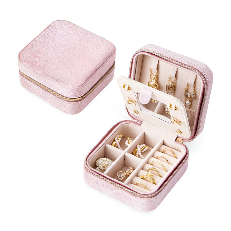 Boîte à bijoux nomade rose en velours avec compartiments et rangements pour bagues et boucles d'oreilles.