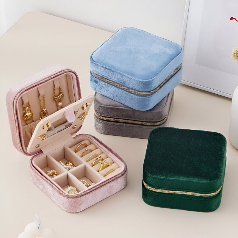 Boîtes à bijoux nomades en velours rose, gris, bleu et vert foncé avec fermeture zip dorée.