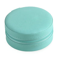 Boîte à bijoux ronde nomade en cuir turquoise avec fermeture zippée.
