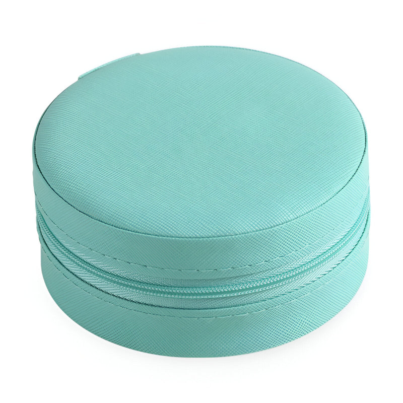 Boîte à bijoux ronde nomade en cuir turquoise avec fermeture zippée.