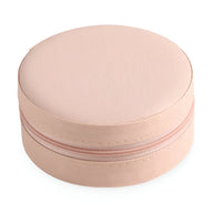 Boîte à bijoux nomade ronde rose avec fermeture éclair et texture lisse.