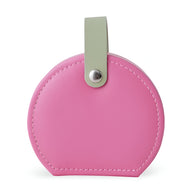 Boîte à bijoux nomade ronde rose avec boucle verte et rivet métallique argenté.