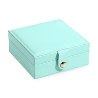 Boîte à bijoux nomade carrée bleu turquoise en cuir avec bouton-pression doré.