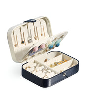 Boîte à bijoux nomade noire format moyen avec compartiments et rangements pour colliers et bagues.