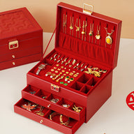 Boîte à bijoux grand format rouge avec multiples tiroirs ouverts et crochets pour colliers, intérieur en velours rouge.