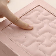 Boîte à bijoux rose grand format en cuir matelassé avec motif cousu et coins renforcés.