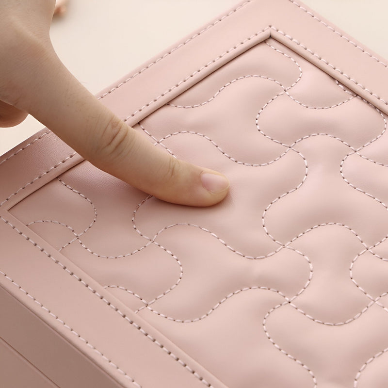 Boîte à bijoux rose grand format en cuir matelassé avec motif cousu et coins renforcés.