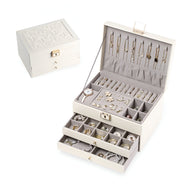 Boîte à bijoux nomade grand format en cuir beige avec multiples tiroirs et compartiments à bijoux, intérieur velours gris.