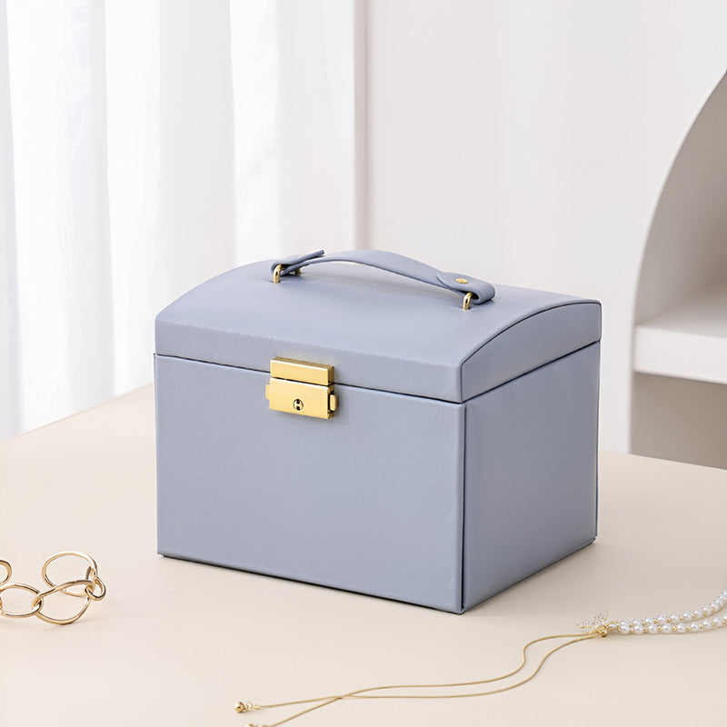 Boîte à bijoux nomade bleu clair, grande capacité, fermeture dorée, poignée supérieure élégante.