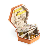 Boîte à bijoux nomade hexagonale bi-colore orange et jaune avec compartiments et porte-boucles intégré.