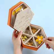 Boîte à bijoux hexagonale bi-colore orange et jaune avec compartiments et support boucles d’oreilles.
