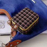 Boîte à bijoux nomade mini format à motif carreaux marron avec fermeture éclair dorée et détail cuir marron.
