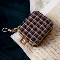 Boîte à bijoux nomade mini marron à carreaux roses avec fermeture éclair et crochet doré.