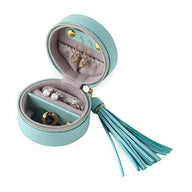 Boîte à bijoux ronde turquoise avec pompon assorti et intérieur organisé en tissu gris clair.