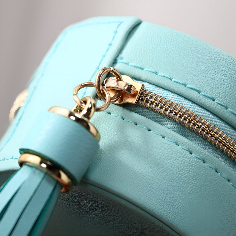 Boîte à bijoux mini bleue en cuir avec fermeture éclair dorée et pompon assorti.