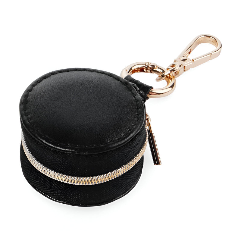 Boîte à bijoux nomade ronde mini format en cuir noir avec fermeture éclair dorée et mousqueton élégant.