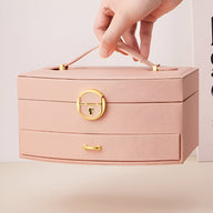 Boîte à bijoux nomade rose avec poignée et fermoir doré, modèle Simone.