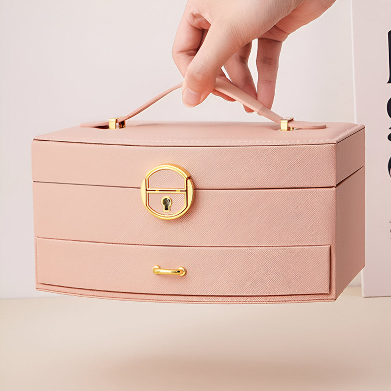 Boîte à bijoux nomade rose avec poignée et fermoir doré, modèle Simone.