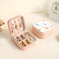Boîte à bijoux rose avec intérieur compartimenté, motif animaux colorés sur le couvercle blanc.
