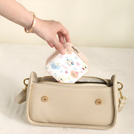 Boîte à bijoux nomade blanche avec motif d'animaux colorés, forme carrée compacte.