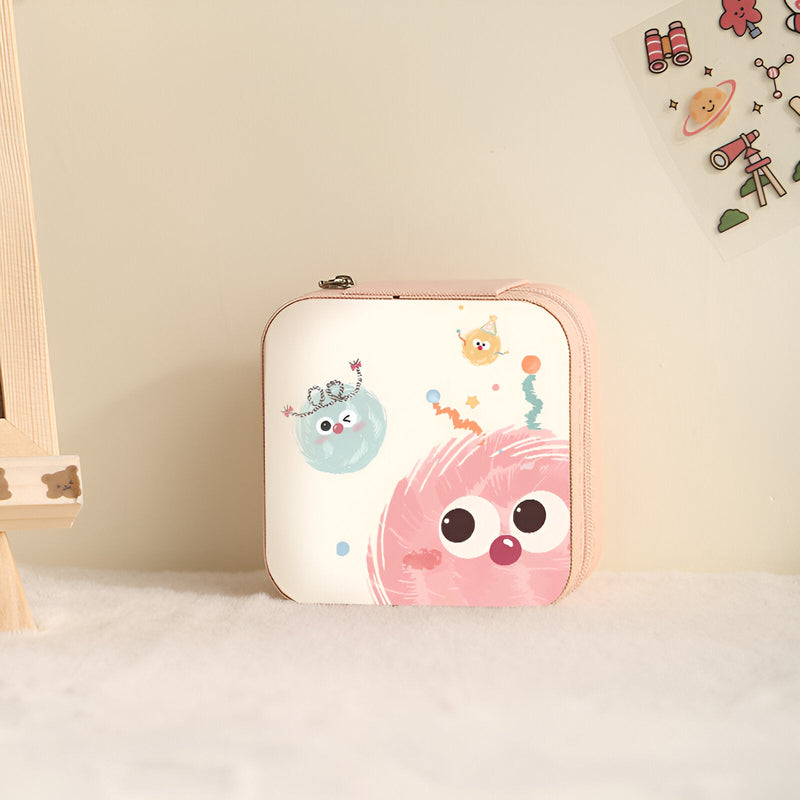 Boîte à bijoux carrée rose et blanche avec motifs monstres colorés joyeux.